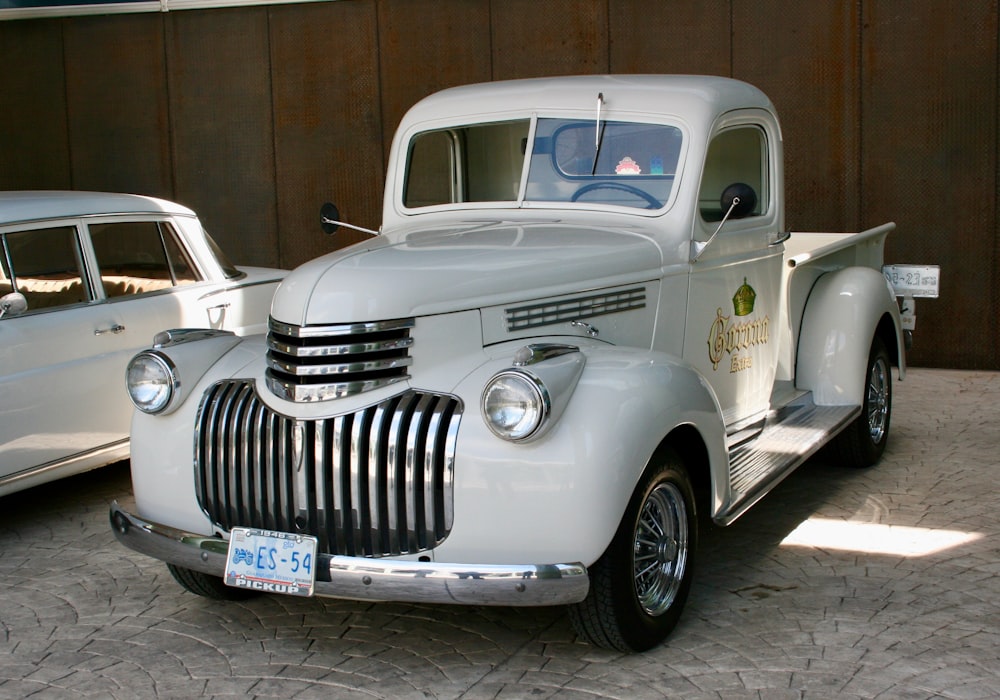 a white truck parked next to a white car