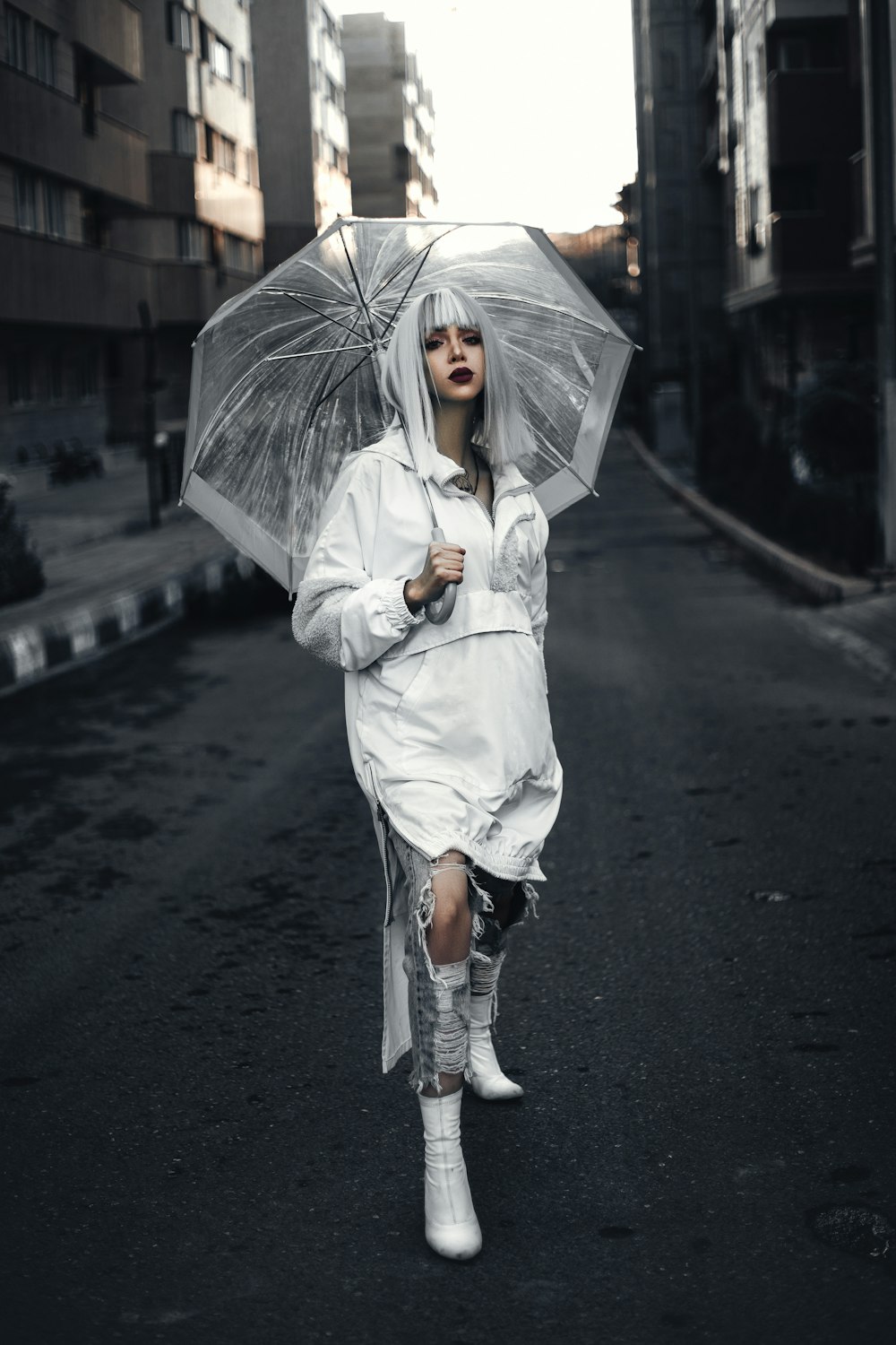 a woman walking down a street holding an umbrella