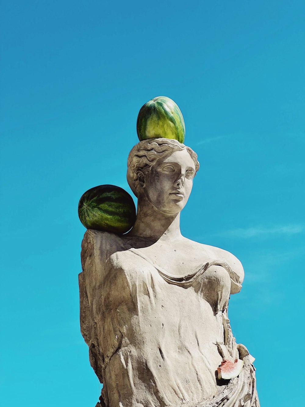 a statue of a woman with a watermelon on her head