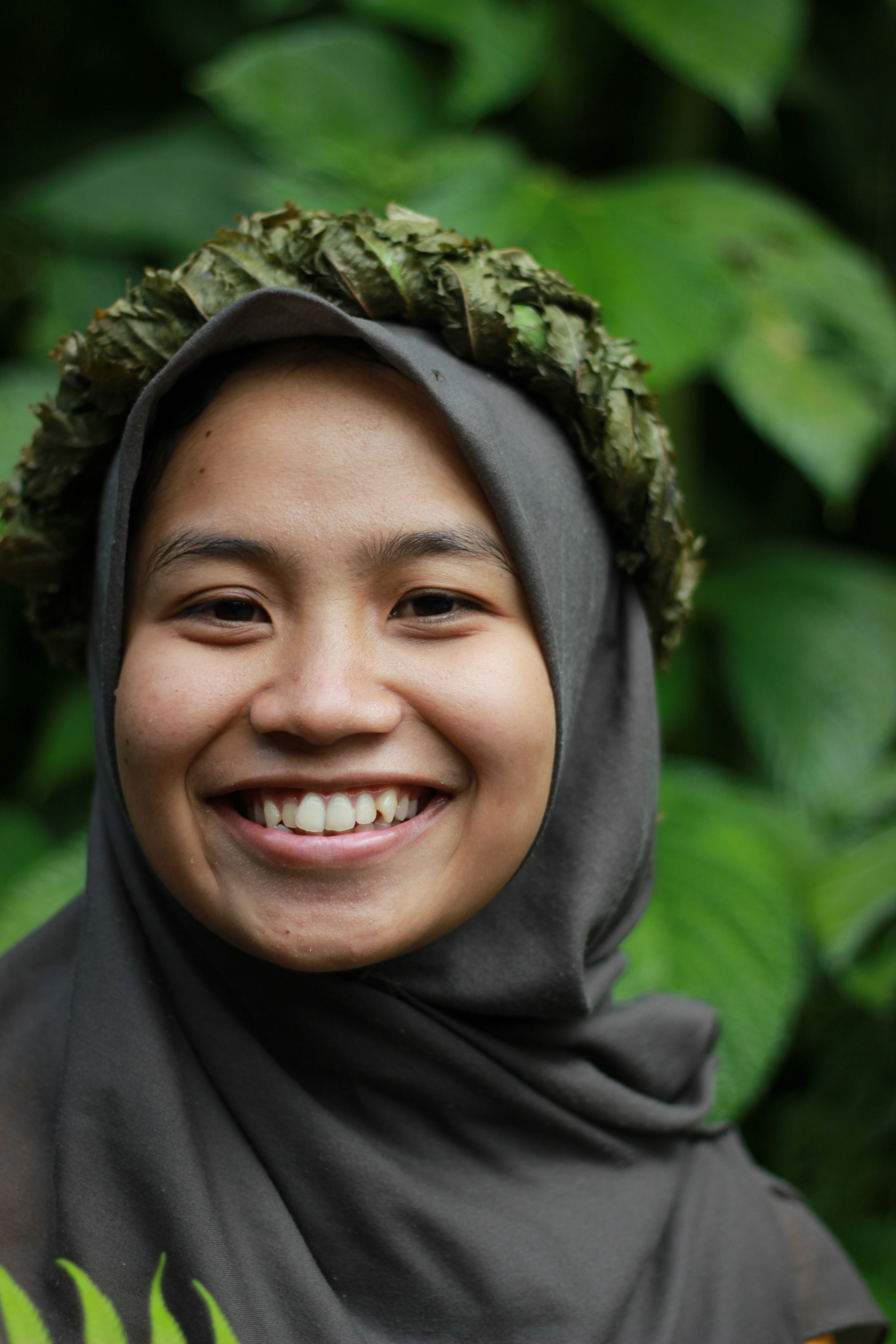 Seorang wanita yang mengenakan jilbab tersenyum ke depan kamera