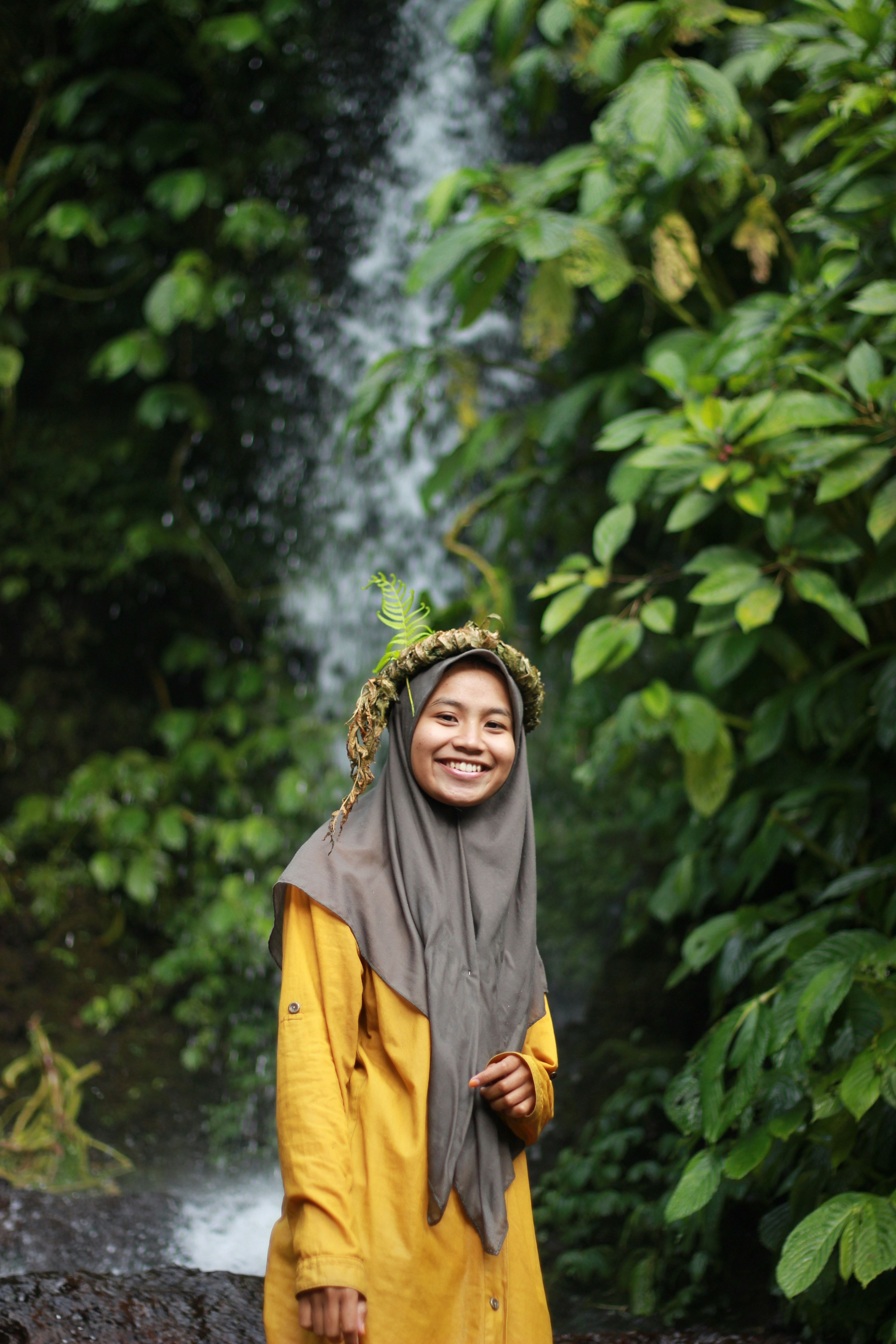 Seorang wanita berdiri di depan air terjun