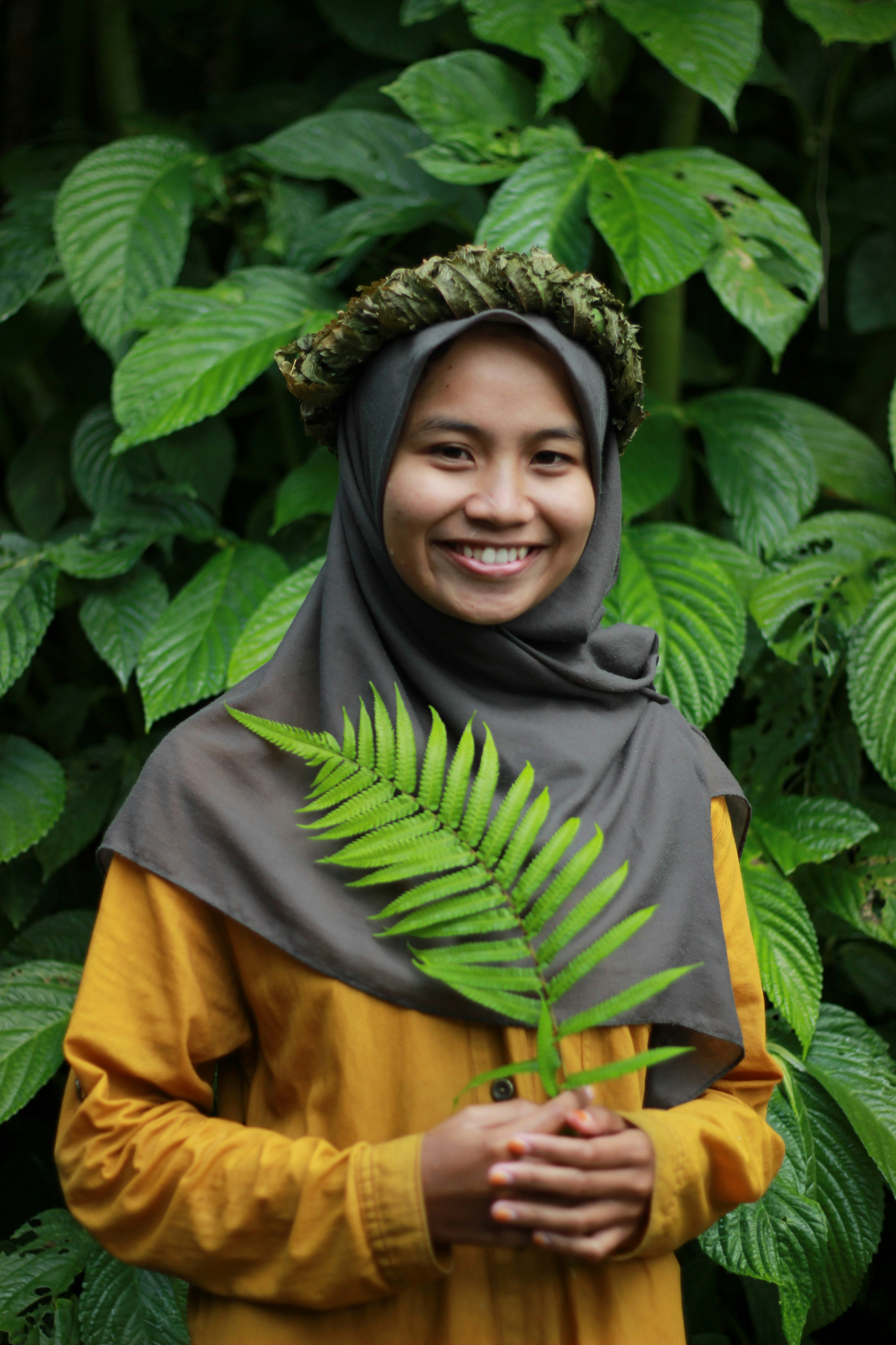 Seorang wanita berjilbab memegang tanaman