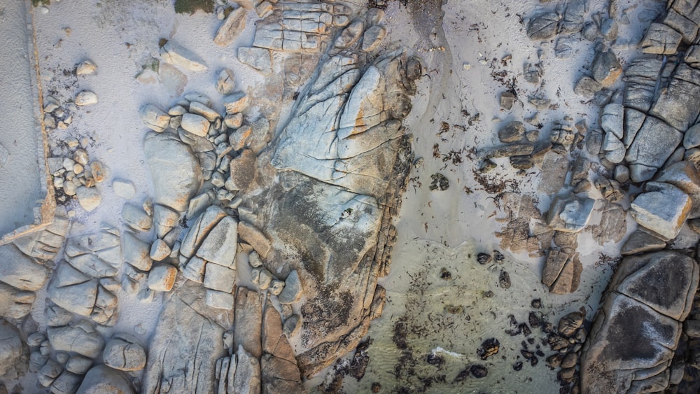 an aerial view of a beach with rocks and sand