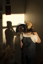 a woman standing in front of a mirror in a room