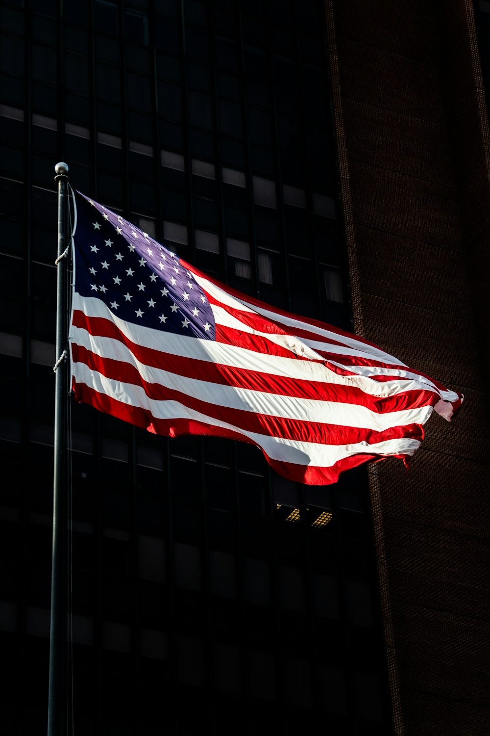 a large american flag flying in the wind