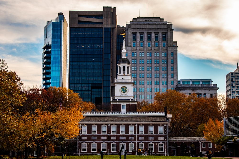 a large building with a clock tower in the middle of a park