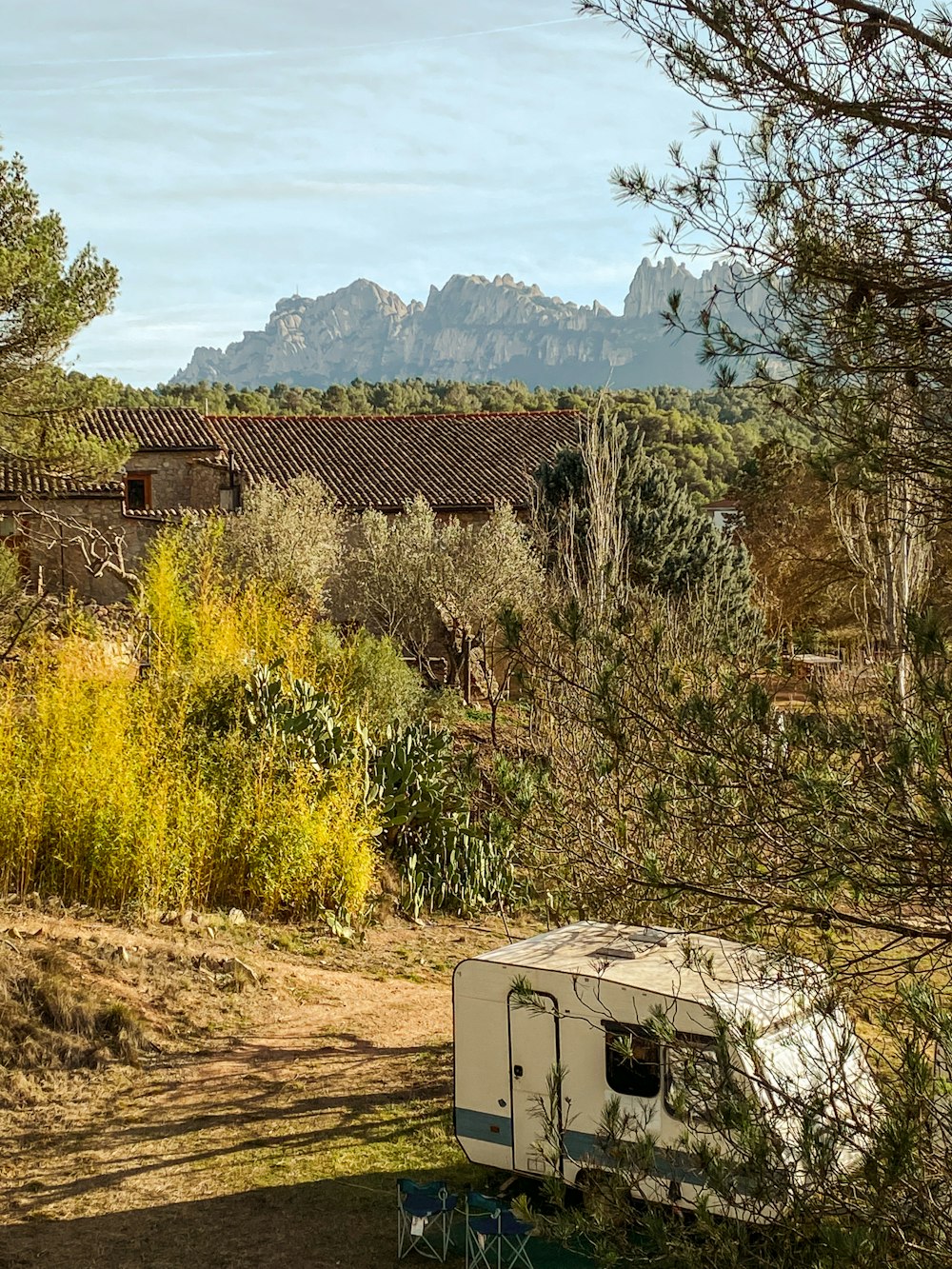 a trailer is parked in a field with mountains in the background