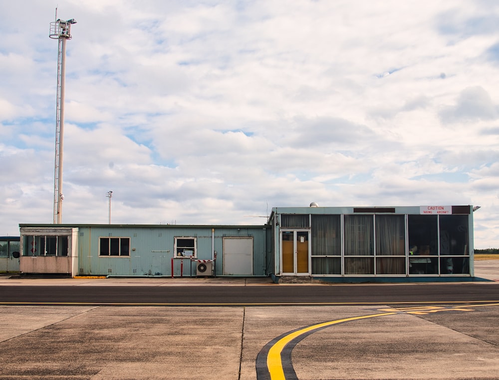 Un edificio azul sentado encima de la pista de un aeropuerto