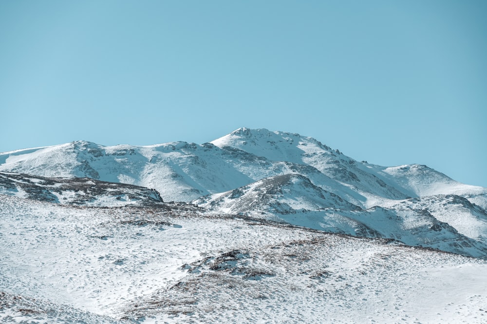 a mountain covered in snow under a blue sky