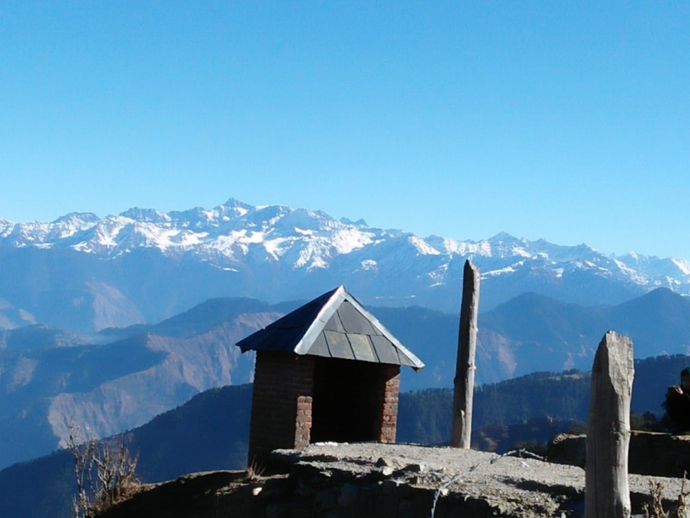 a view of a mountain range with a small hut in the foreground