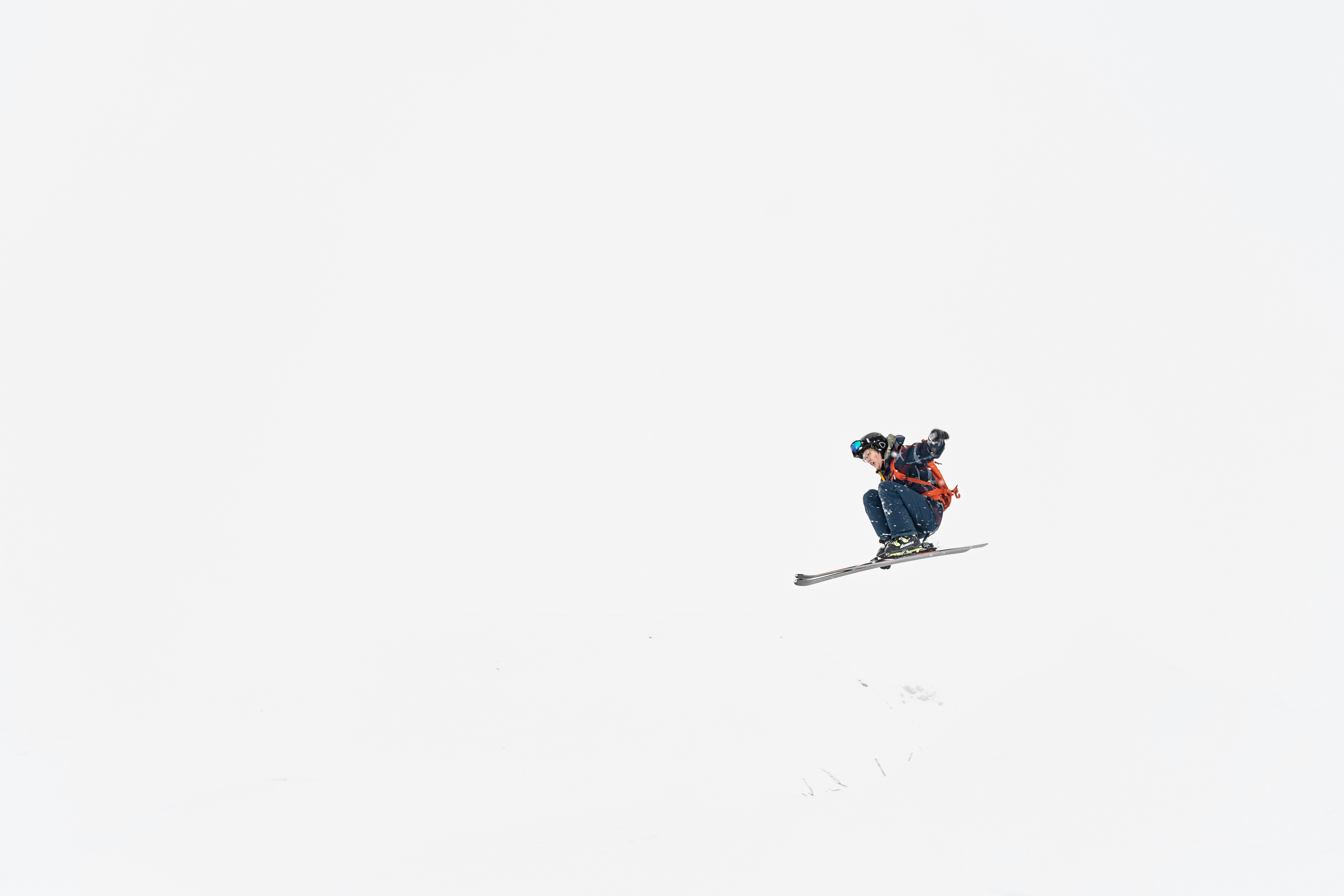 Man riding snowboard down snow covered slope