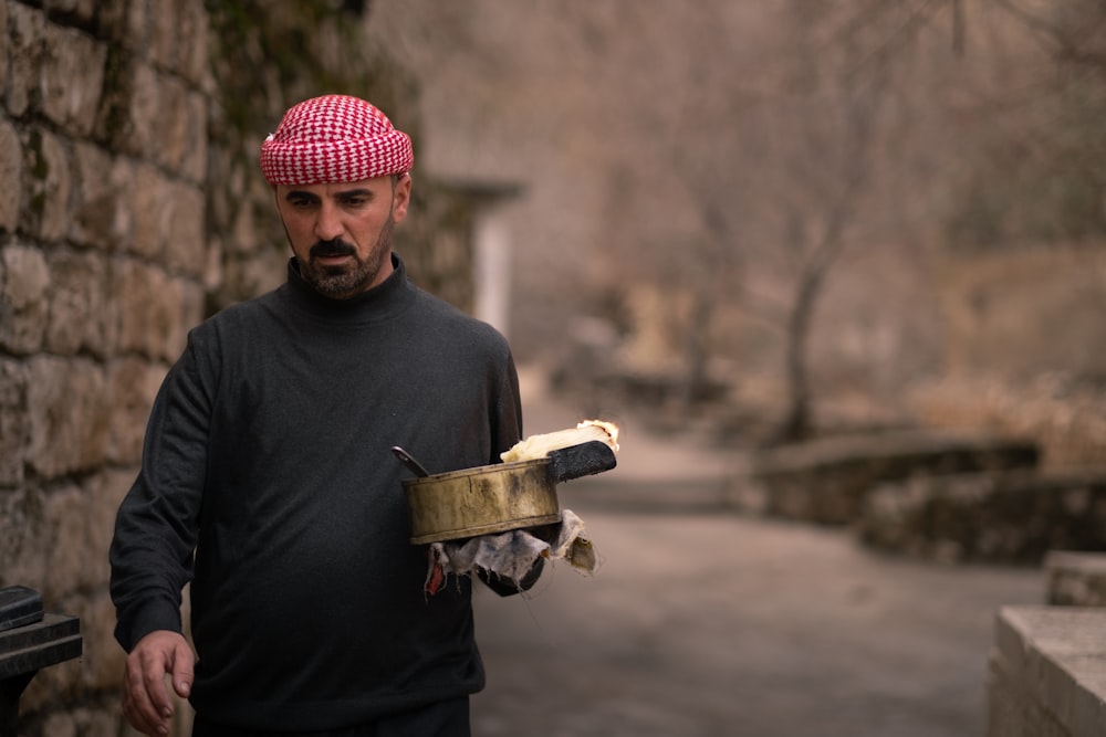 a man in a red and white turban holding a piece of bread