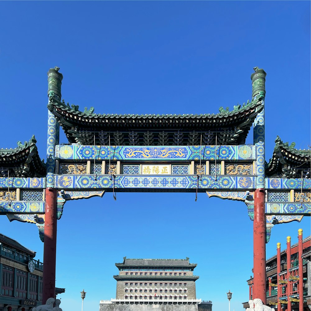 a blue and red archway with a building in the background