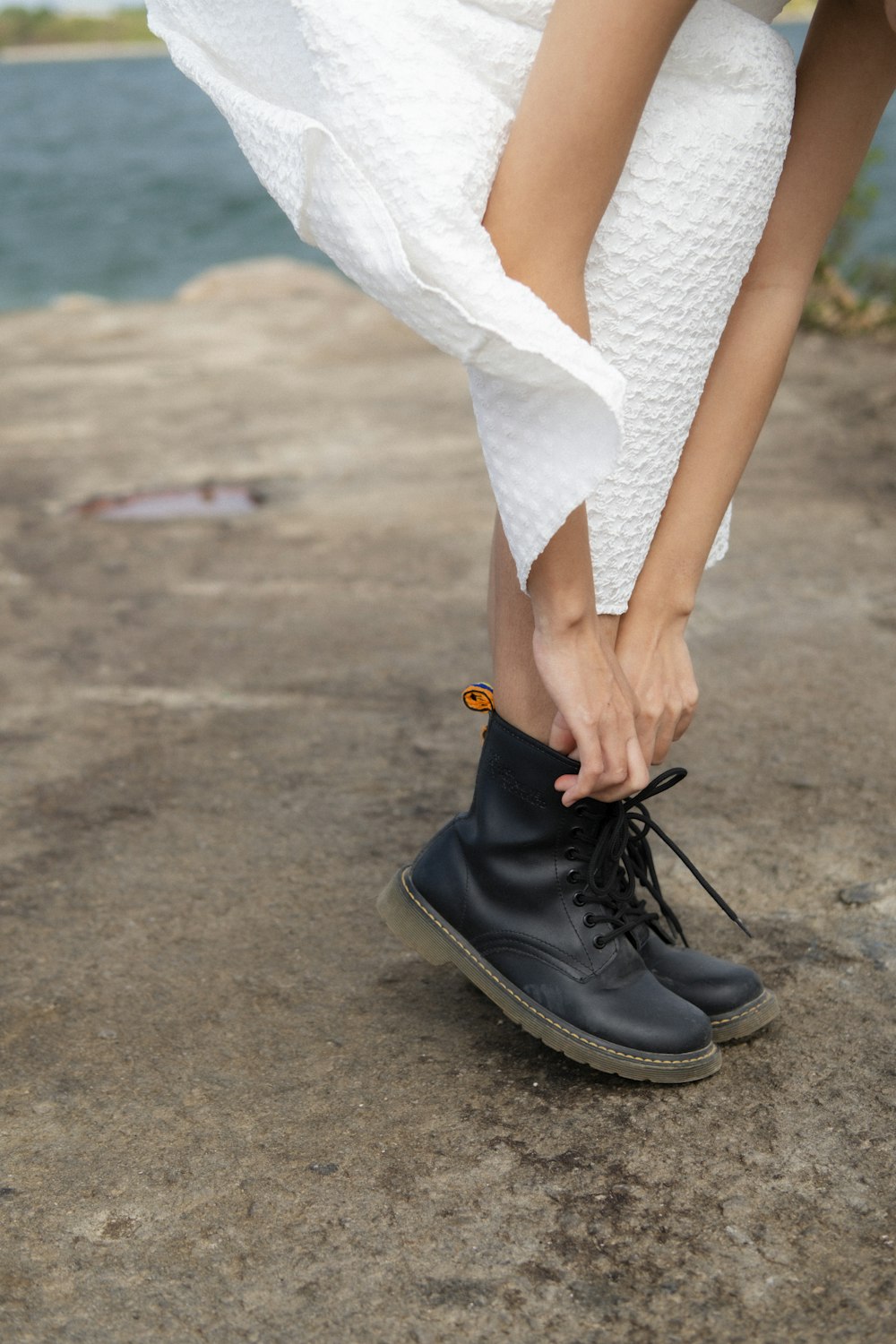 a close up of a person tying a pair of shoes