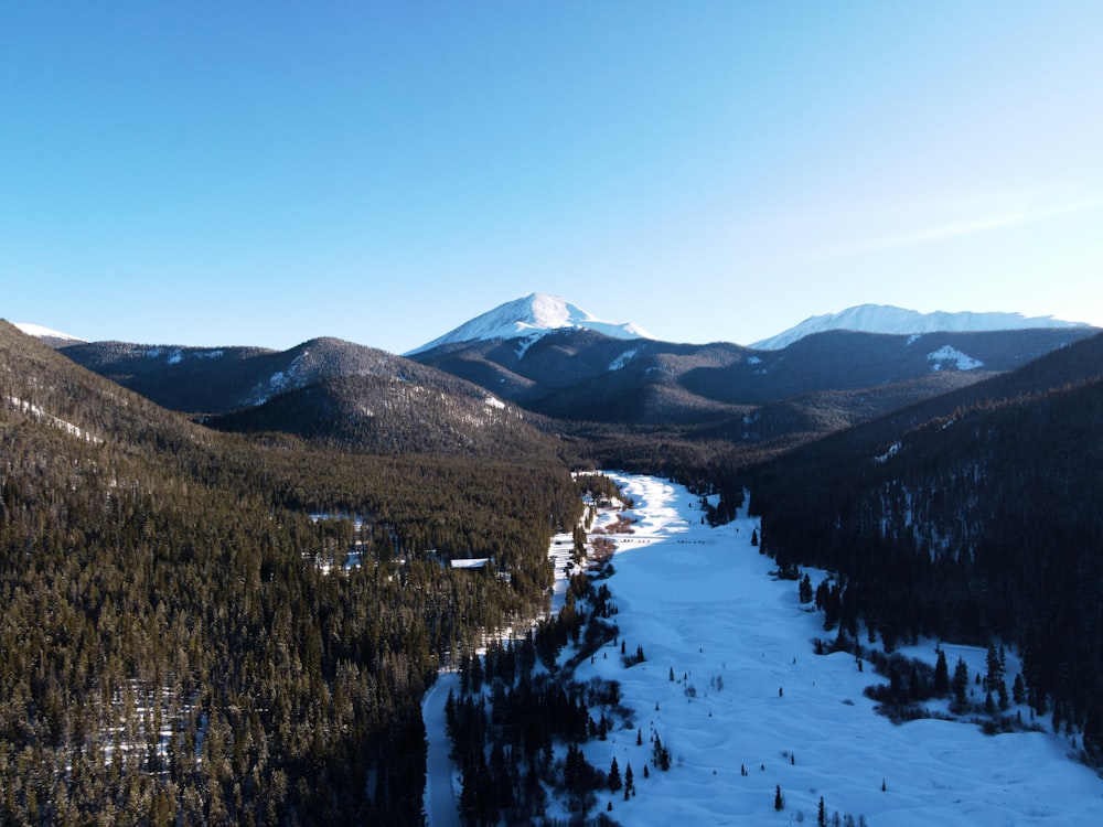 a view of a snow covered mountain with a river running through it