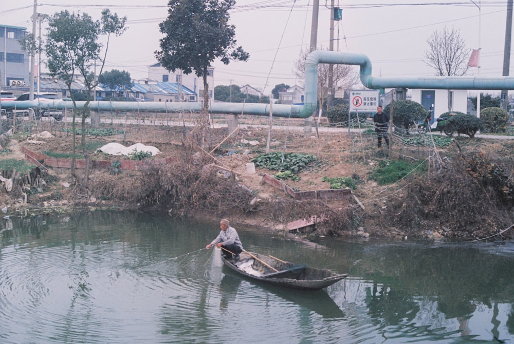 a man in a small boat on a body of water