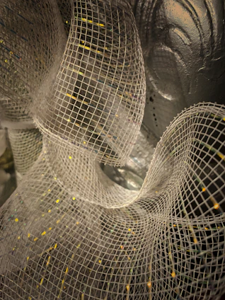 A close-up of layered non-woven fabrics being laminated in a modern industrial setting.