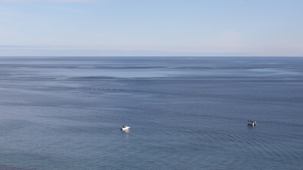 a couple of boats floating on top of a large body of water