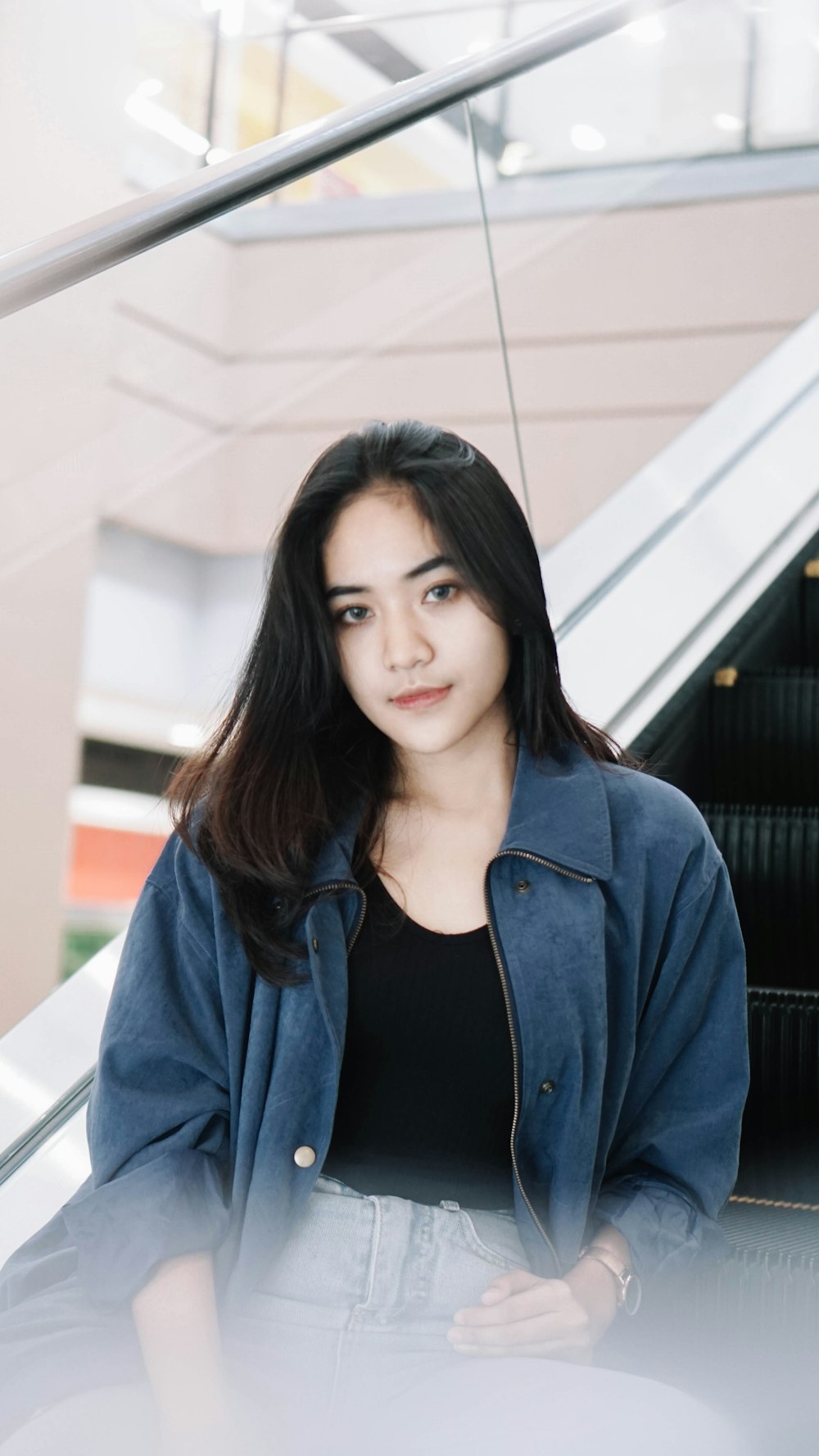 a woman standing in front of an escalator