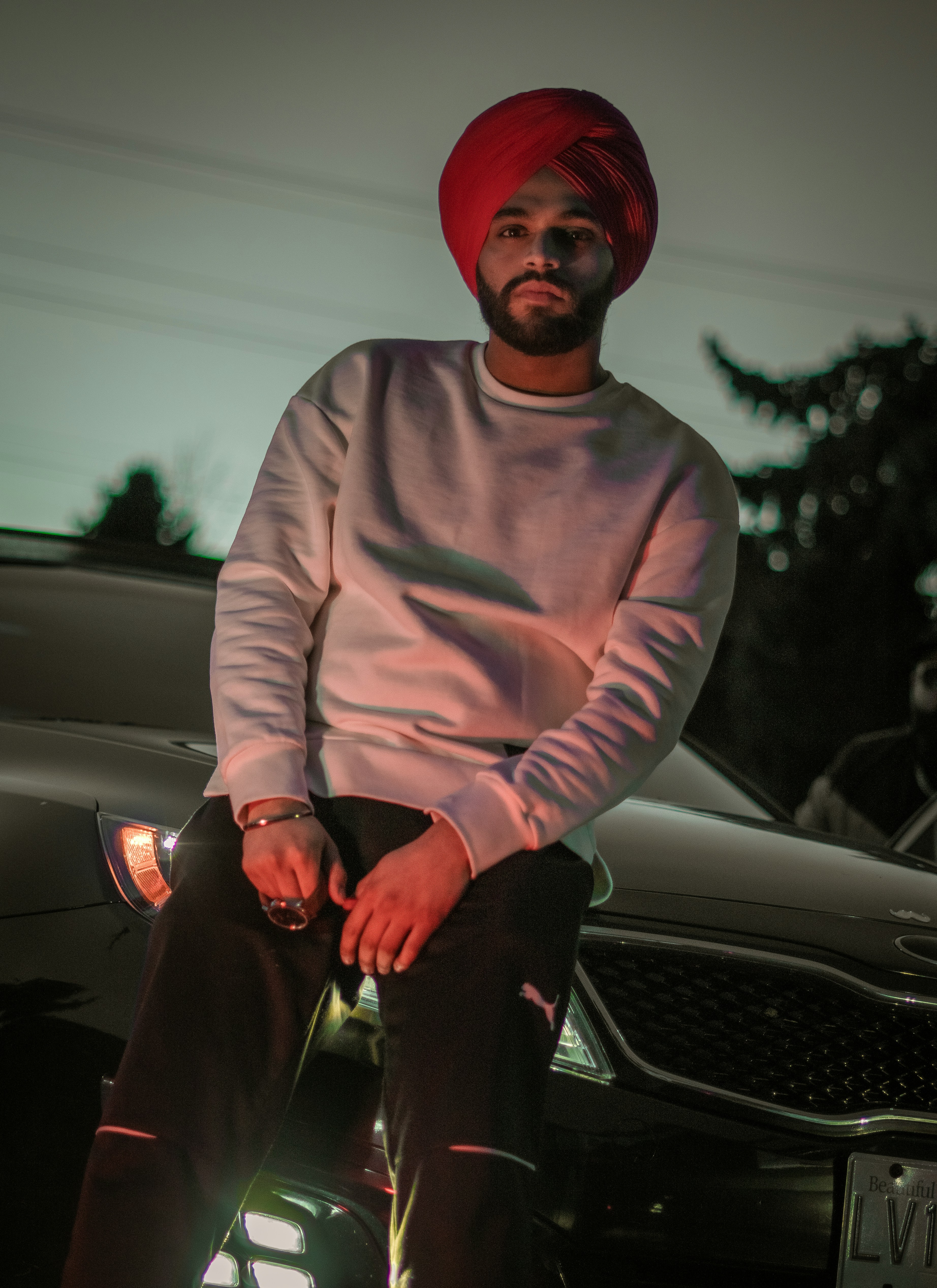 a man in a turban sitting on a car