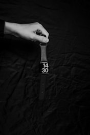 a black and white photo of a person holding a watch