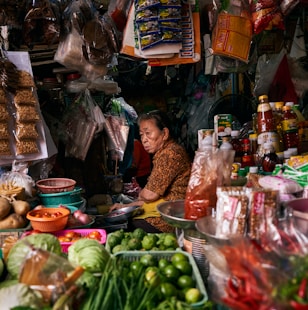 a woman sitting at a table filled with lots of food