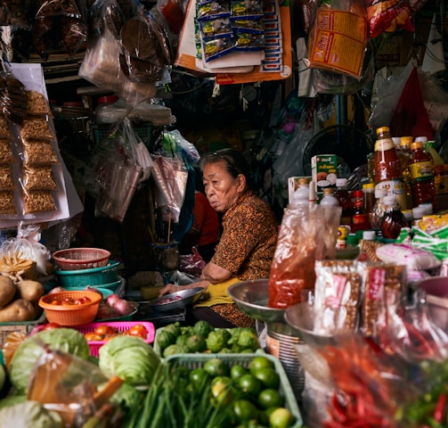a woman sitting at a table filled with lots of food