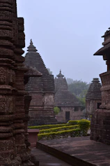 a row of stone buildings with a clock tower in the background