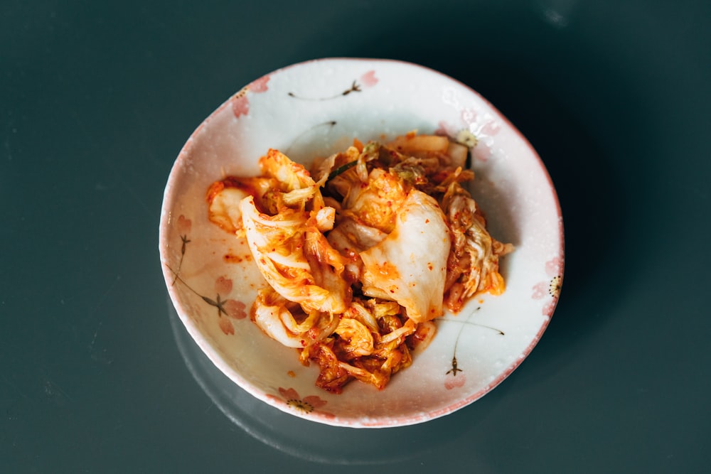 a white bowl filled with food on top of a table