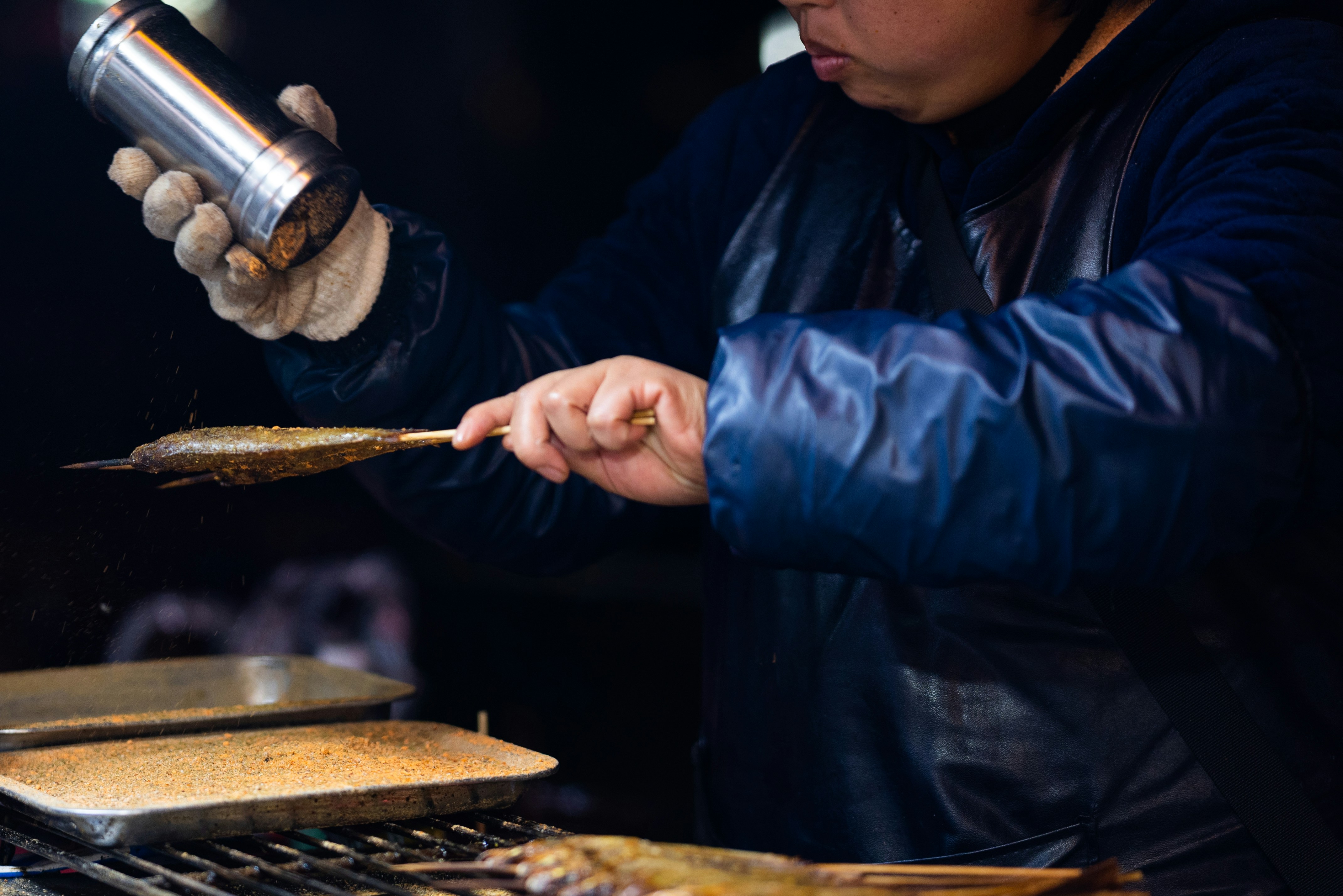 fish sauce Asian condiment production - a man in a leather jacket is cooking on a grill