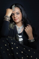 a woman in a black dress with a necklace on her head