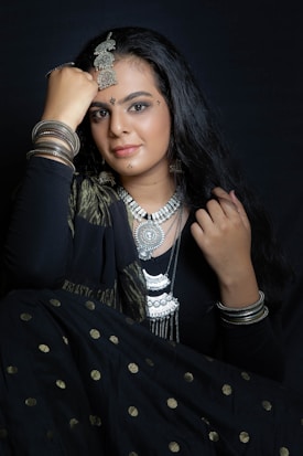 a woman in a black dress with a necklace on her head