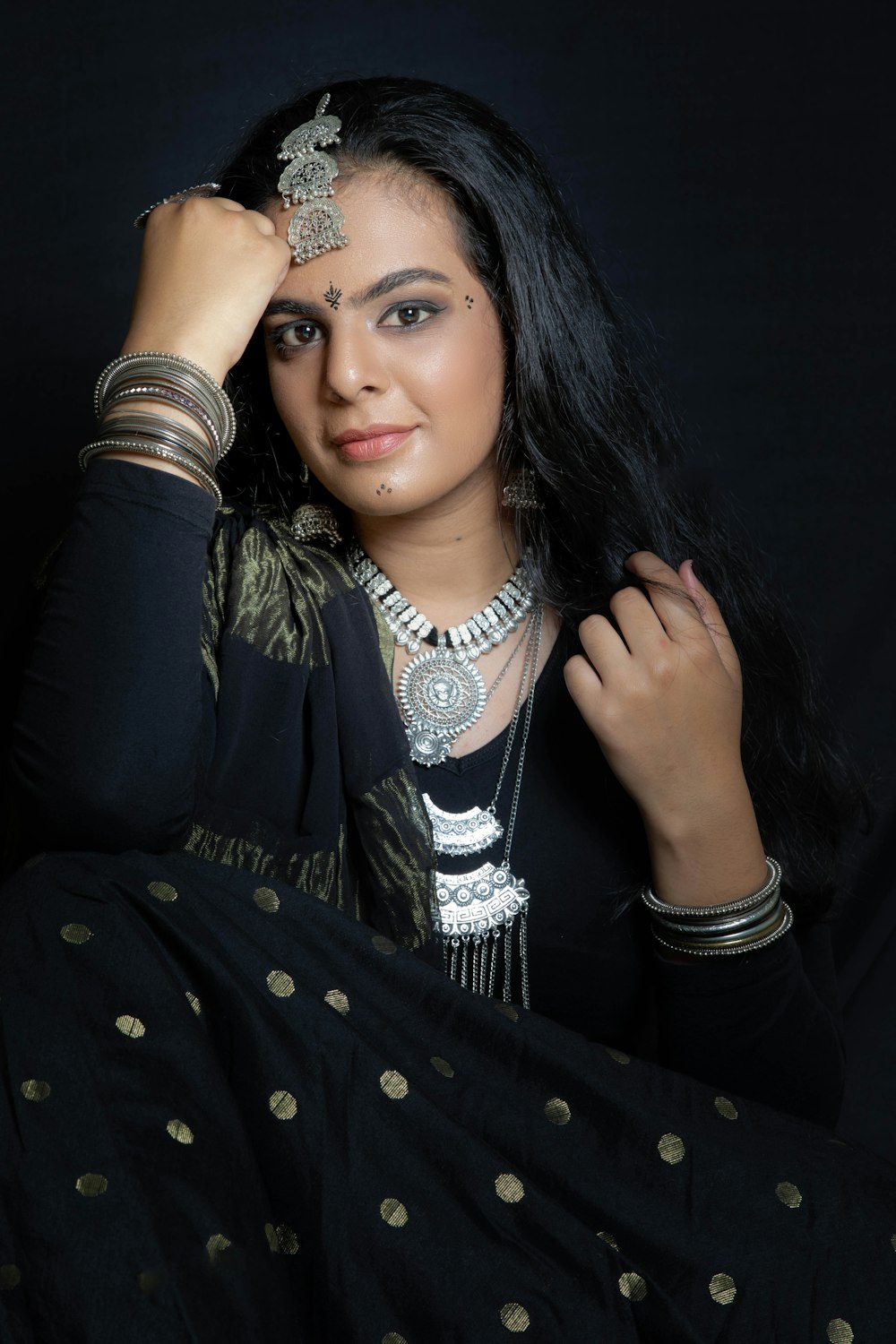 a woman in a black dress with a necklace on her head