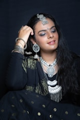 a woman wearing a black outfit and jewelry