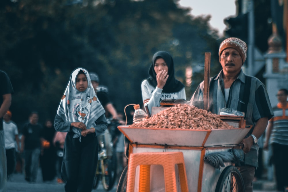 a man pushing a wheelbarrow filled with lots of food