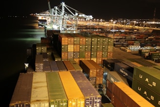 cargo containers are stacked on top of each other at night