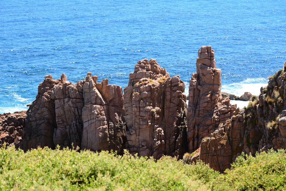 a group of rocks sitting on top of a lush green hillside