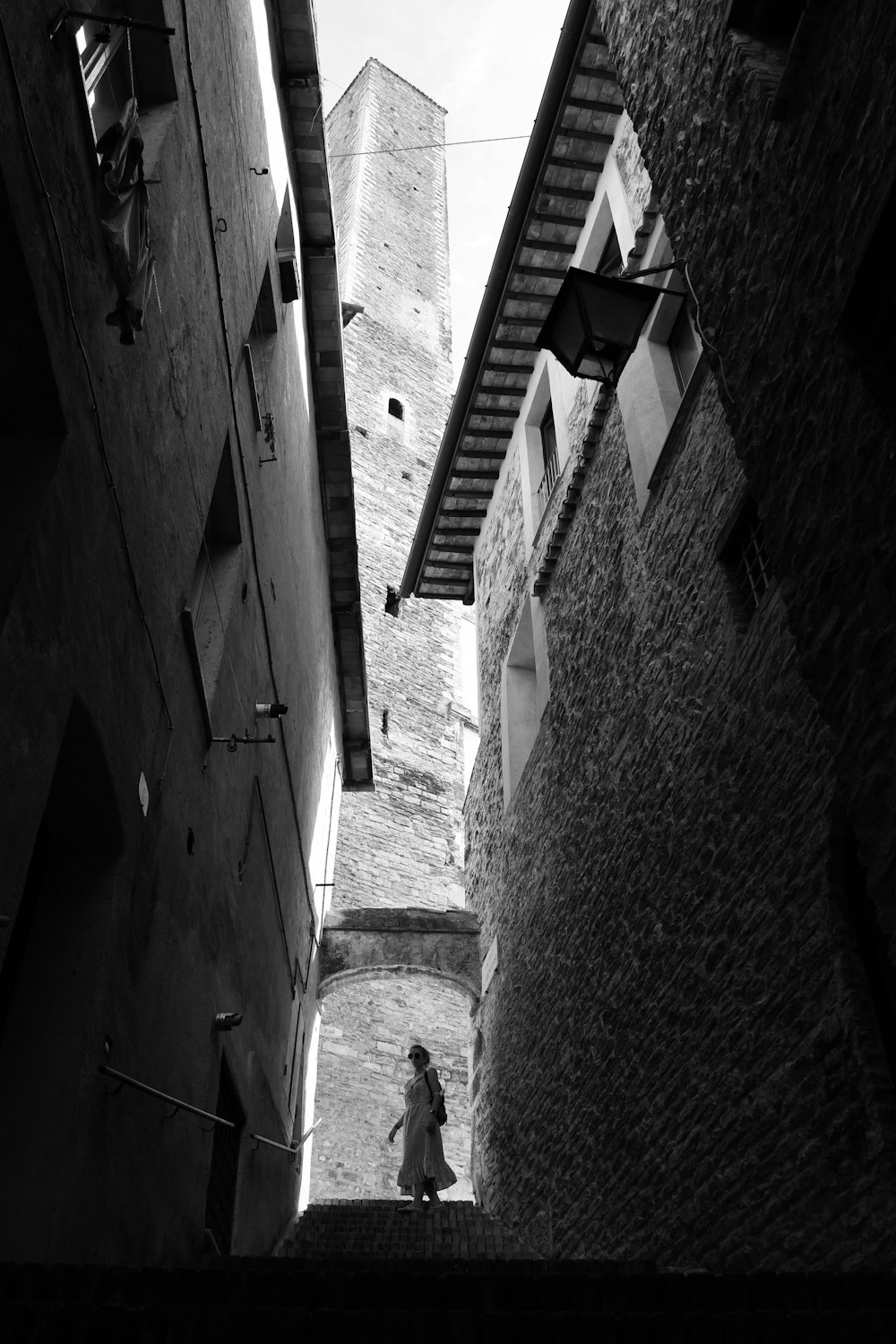 a black and white photo of a person walking down a street