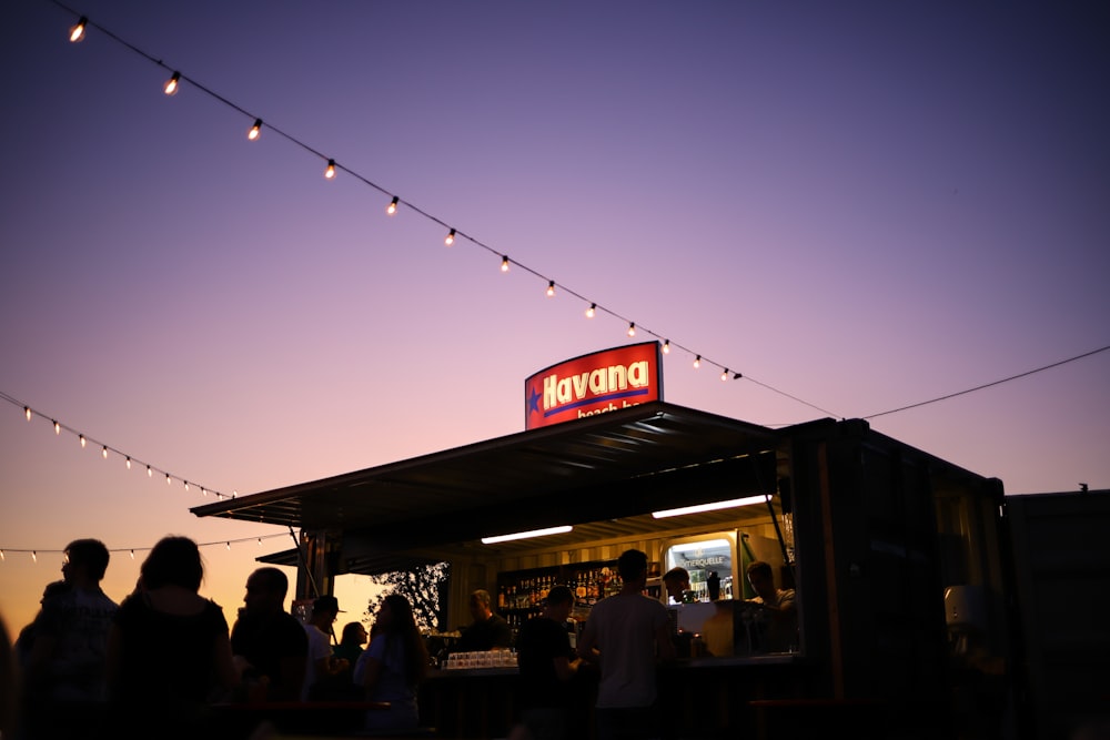 a group of people standing around a food stand