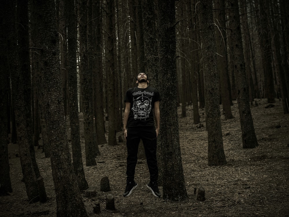 a man standing in the middle of a forest