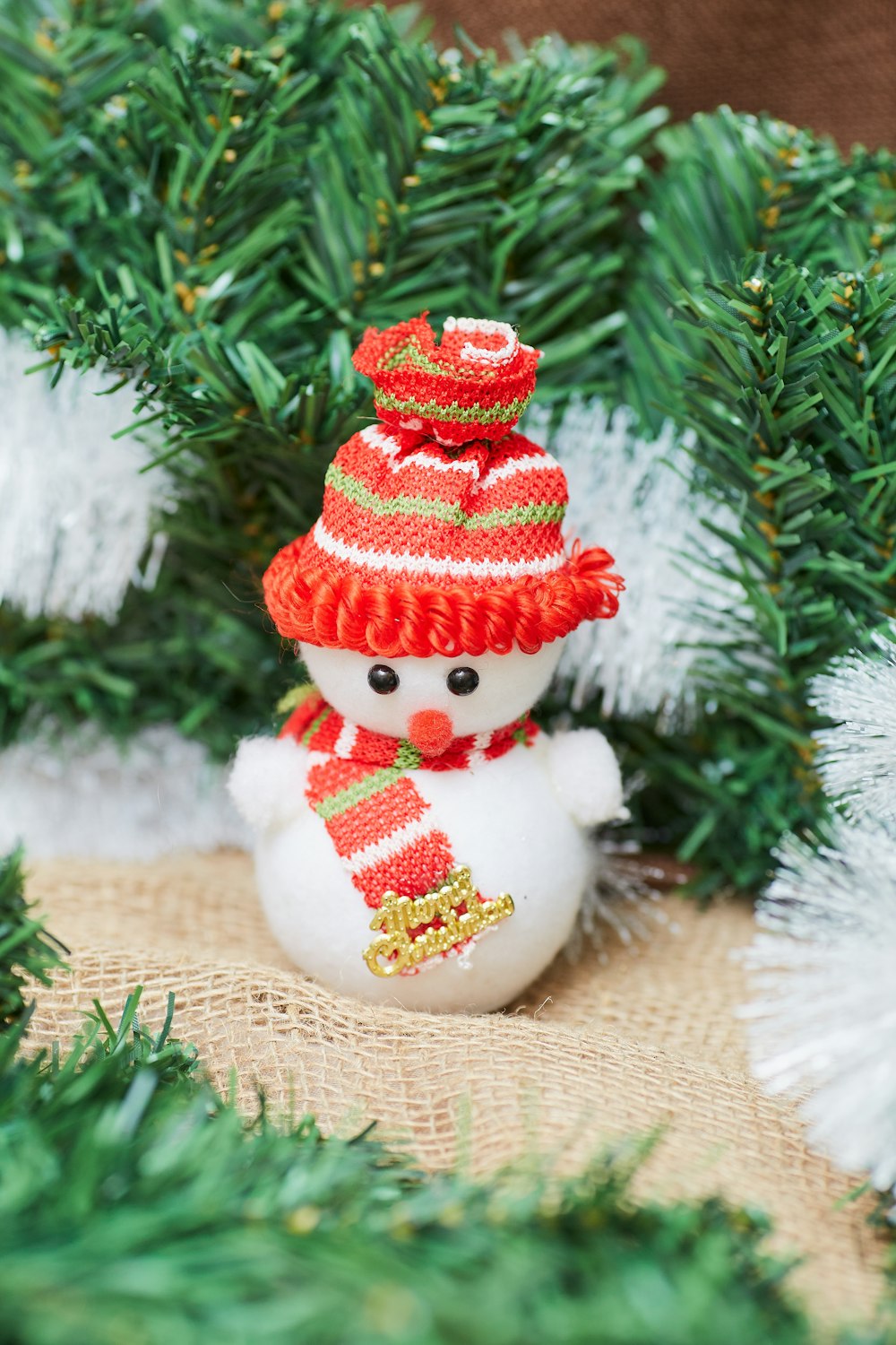 a snowman ornament sitting on top of a christmas tree