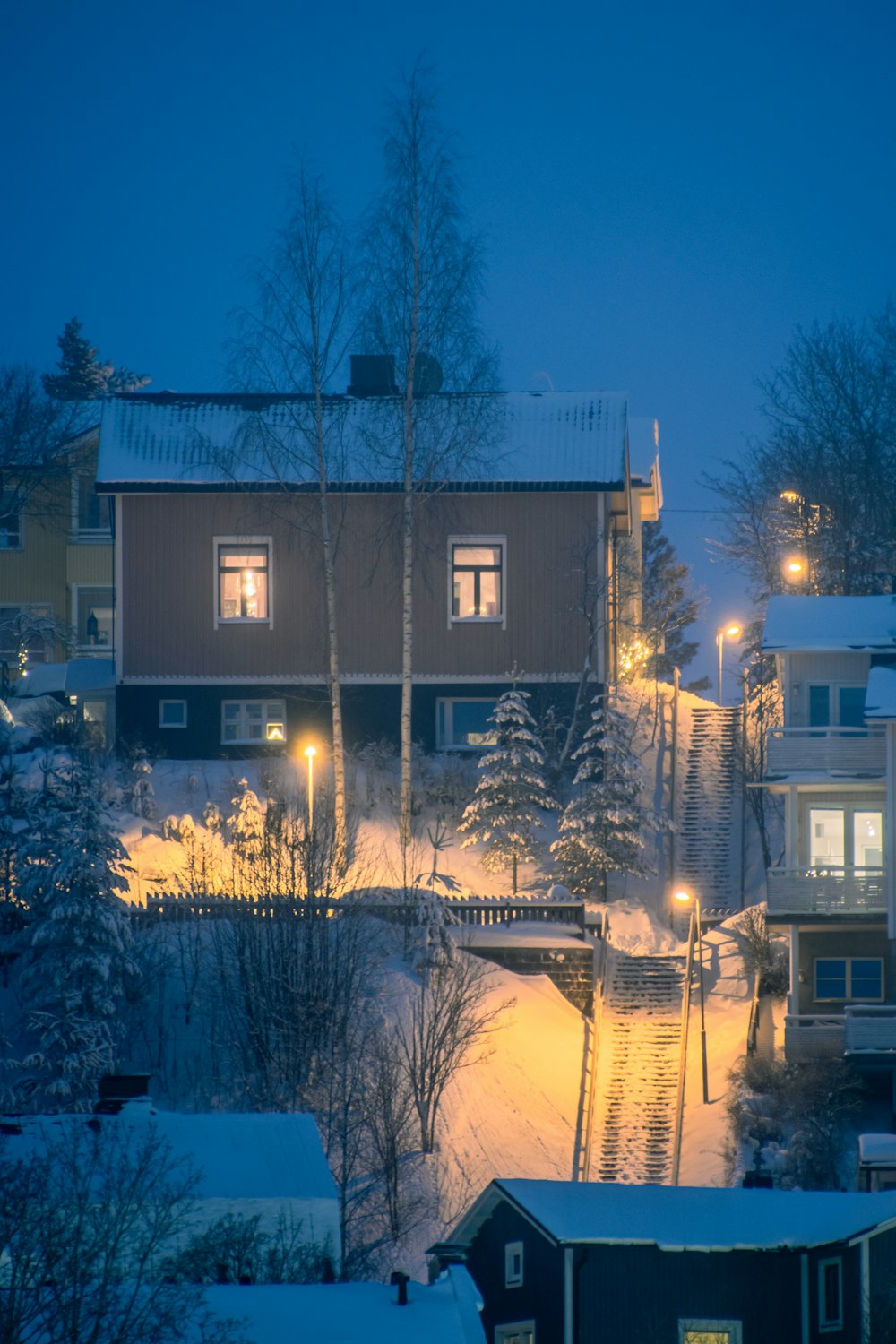 a night scene of a town with snow on the ground