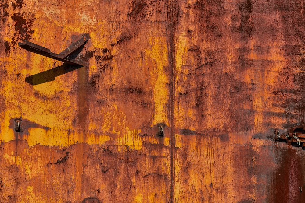 a rusted wall with a pair of scissors stuck in it