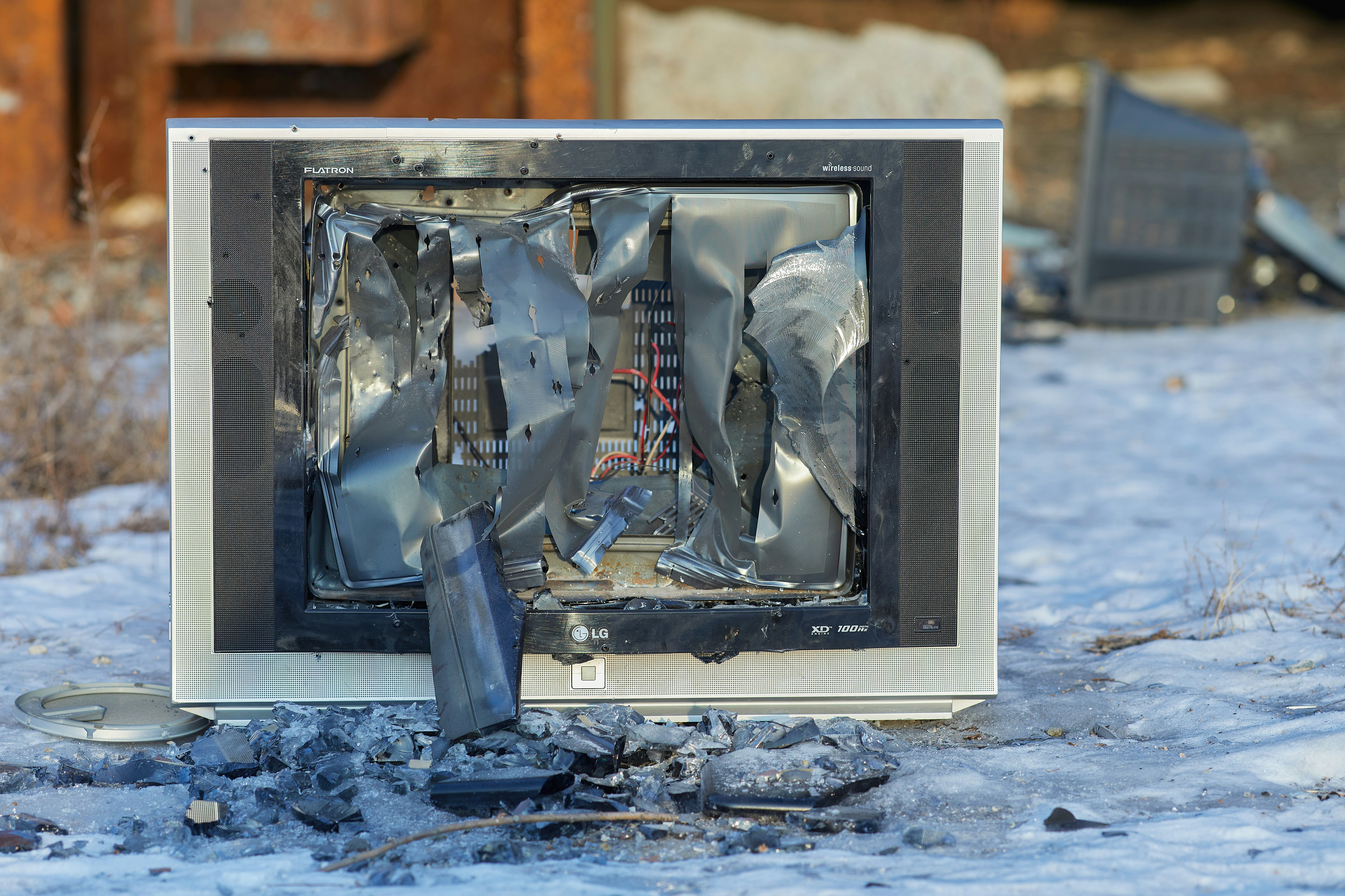 a broken television sitting on top of snow covered ground