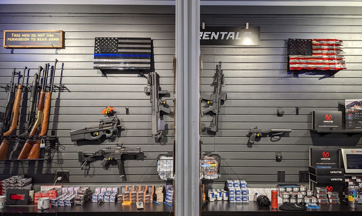 Interior wall of a firearms shop with hanging long guns