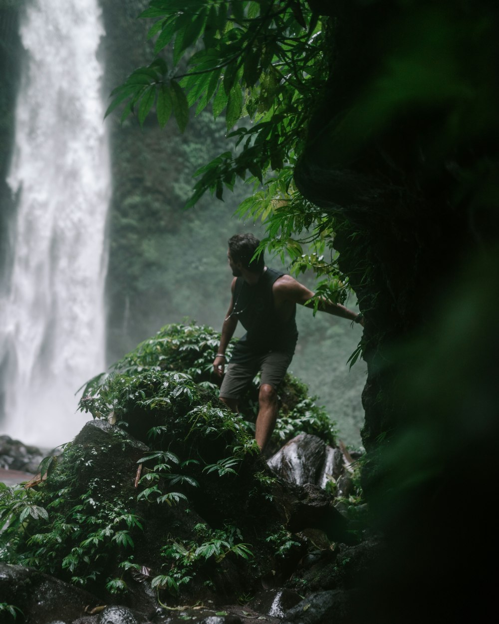 a man standing in front of a waterfall