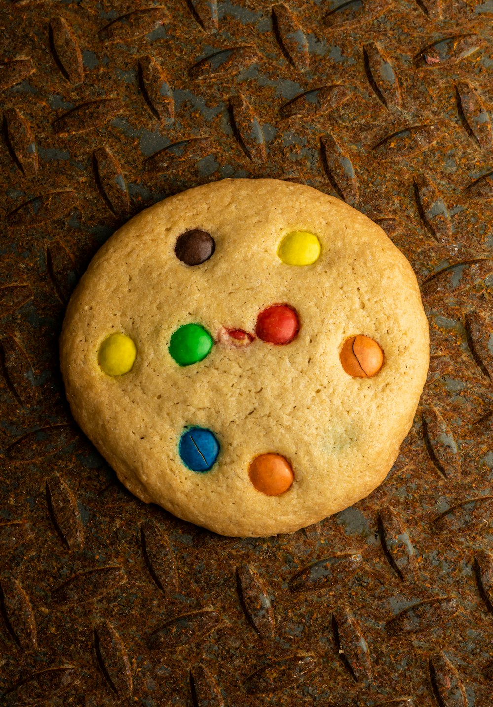 a cookie with m & m on it sitting on a table