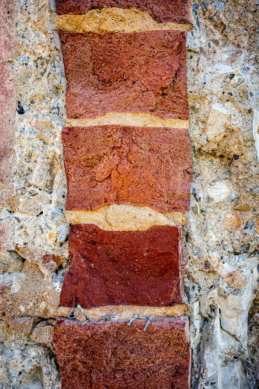 a stone wall with a red and yellow stripe painted on it