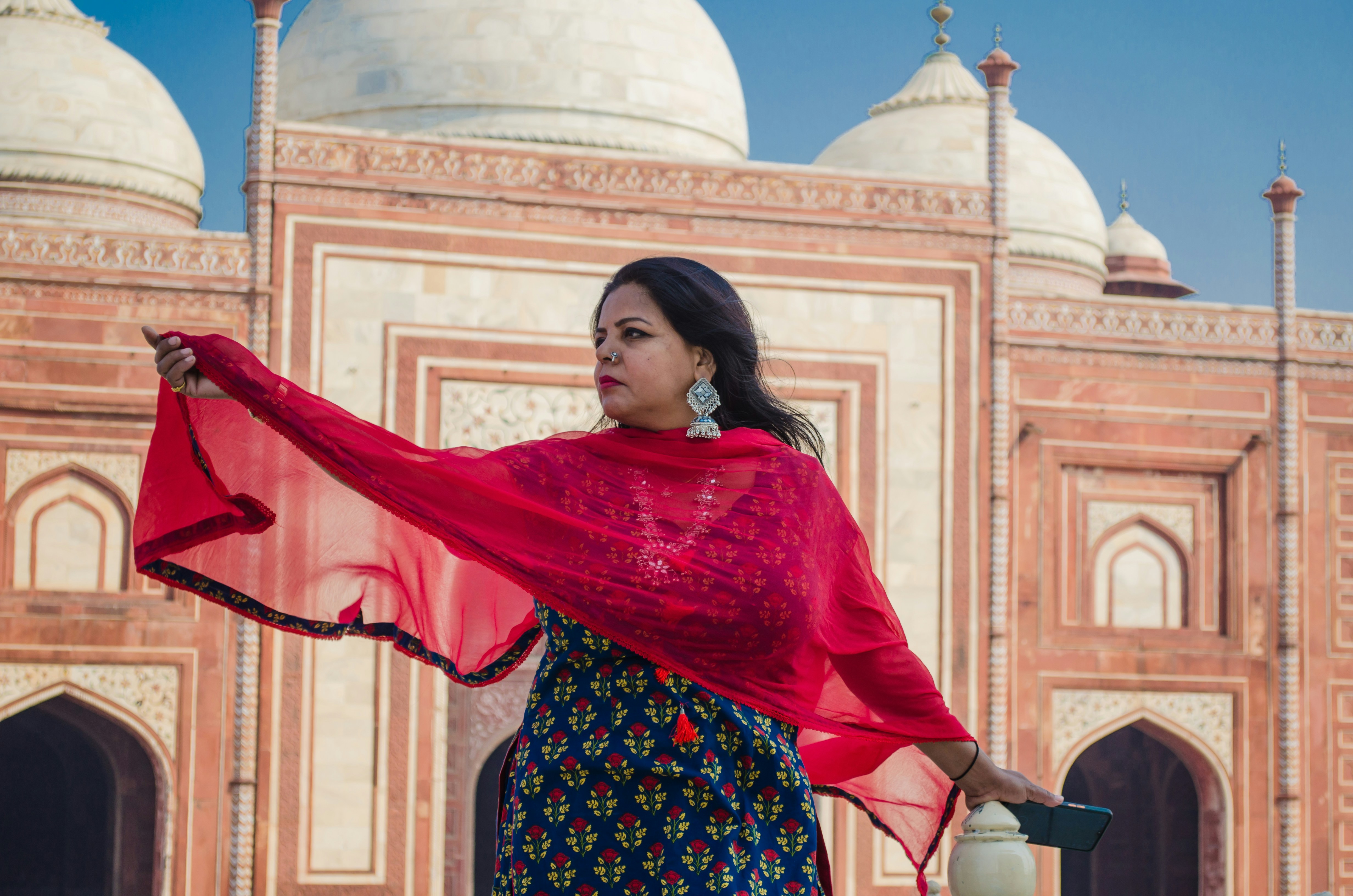 a woman with a red scarf standing in front of a building