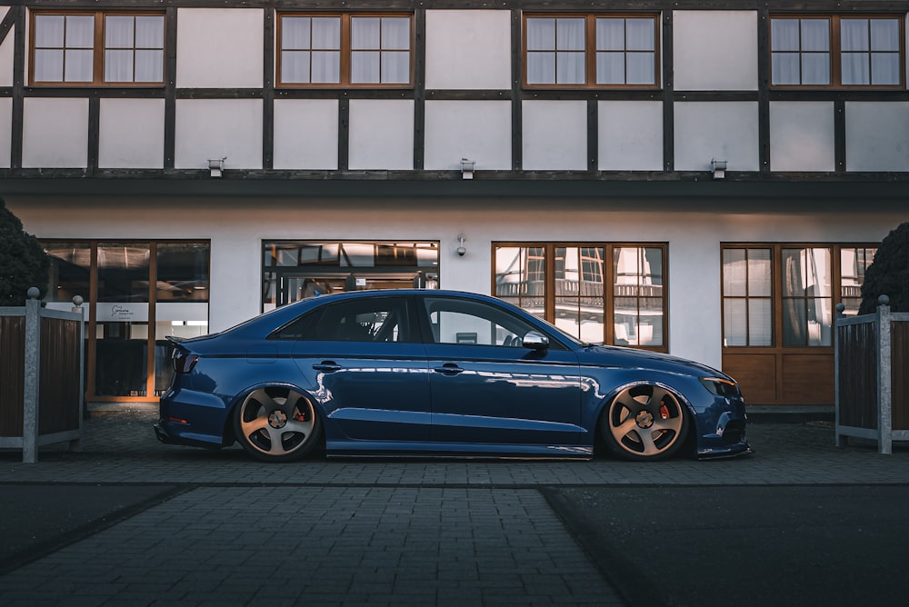 a blue car parked in front of a building